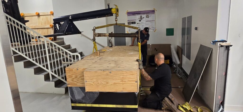 Armstrong Scientific Transport rigging team relocating optical table up staircase during laboratory move