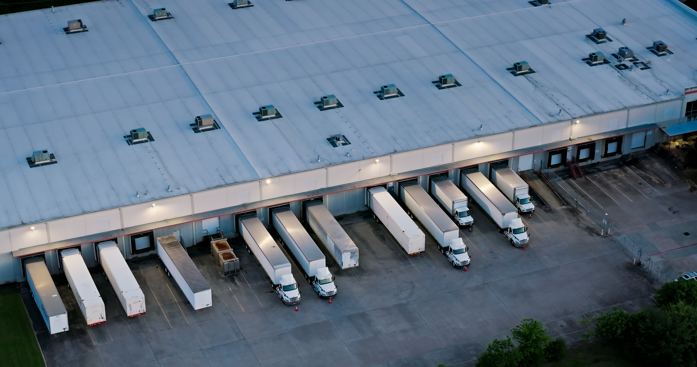 Refrigerated transport trailers at a loading dock, illustrating dry ice vs plug-in transport logistics.